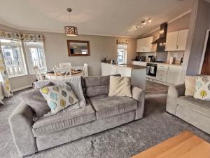 a living room with a couch and a kitchen at Waterside Retreat in Wisbech