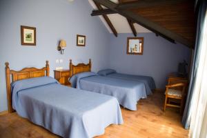 three beds in a room with white walls and wooden floors at Hotel Balcon de Aguera in San Martín