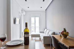 una bottiglia di vino seduta su un tavolo in soggiorno di Thessaloniki Central Apartment 2 a Salonicco