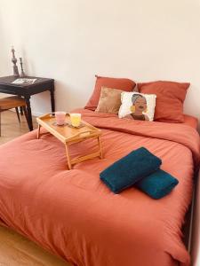 a orange bed with a table on top of it at La casa venta in Tournon-sur-Rhône