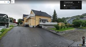 a house on a street with a driveway at Bright and pleasant basement apartment near downtown, Lys og trivelig kjellerleilighet i sentrumsnært in Kirkenes