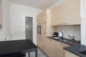チューリッヒにあるDowntown Dream 2 5BR with Balcony and Style BA 51のキッチン(木製キャビネット、黒いカウンタートップ付) +9枚の写真
