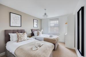 a bedroom with two beds and a tv at Stunning Detached House with Driveway Parking, Office Room, Self-Check-In, Fast WiFi and Smart TV with Sky and Netflix by Yoko Property in Milton Keynes +39 photos