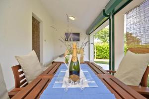 a wooden table with a bottle of wine on it at Adriatic Vacation House in Ližnjan