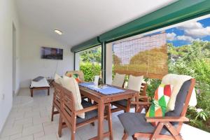 a dining room with a table and chairs on a patio at Adriatic Vacation House in Ližnjan