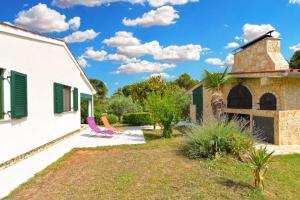 a garden with chairs and a building at Adriatic Vacation House in Ližnjan