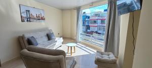 a living room with a couch and chairs and a window at Apartamento familiar en zona norte de Tunja, cerca a Viva, con parking in Tunja