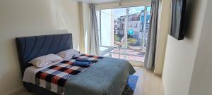 a bedroom with a bed and a large window at Apartamento familiar en zona norte de Tunja, cerca a Viva, con parking in Tunja