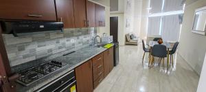 a kitchen with a stove and a counter top at Apartamento familiar en zona norte de Tunja, cerca a Viva, con parking in Tunja