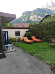 a group of orange chairs sitting in the grass at Maison Sallanches 12 couchages in Sallanches