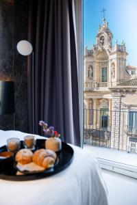 a plate of pastries on a table with a window at Meo Design Suites & Spa in Catania
