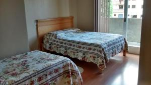 a bedroom with two beds and a window at Estrelatto Residence in Gramado