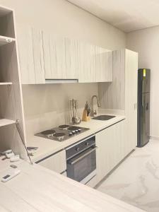 a kitchen with white cabinets and a stove and refrigerator at Sui Loft Apto 1311 in Santa Marta