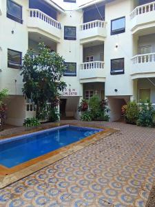 a hotel with a swimming pool in front of a building at V&M Calisto Guesthouse in Mandrem