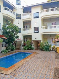 un hôtel avec une piscine devant un immeuble dans l'établissement V&M Calisto Guesthouse, à Mandrem