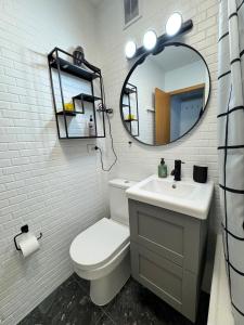 een badkamer met een toilet, een wastafel en een spiegel bij Bright & Cozy Central Studio in Reykjavík