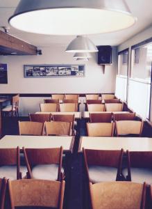 an empty room with tables and chairs and a spotlight at Hôtel Le Monte Pente in Vars
