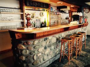 a stone bar with stools in a restaurant at Hôtel Le Monte Pente in Vars