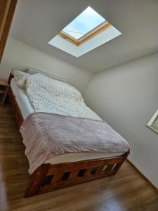 1 dormitorio con 1 cama con tragaluz en Mały Domek, en Stara Kamienica