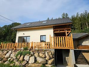 una casa con terraza y pared de roca en Mały Domek, en Stara Kamienica