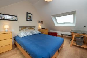 a bedroom with a blue bed and a desk at Ty Eole Maison Tout Confort 10p in Quiberon