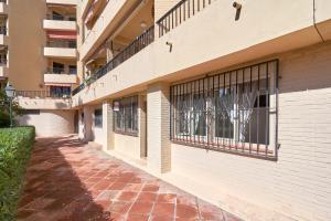 a brick walkway next to a building with barred windows at Rosa Náutica La Herradura in Almuñécar