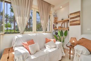 a living room with a white couch and windows at Rosa Náutica La Herradura in Almuñécar +20 photos