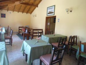 een restaurant met 2 tafels en stoelen met groene tafelkleden bij Hosteria Luz de Luna in Valeria del Mar +15 foto's