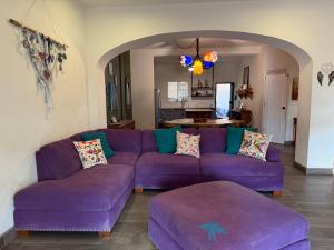 a living room with a purple couch and a table at Casa Amor Por Siempre in Bucerías