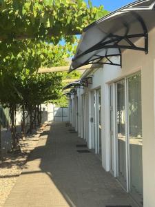 a sidewalk next to a white building with awning at Flyers' Lodge in Porterville +5 photos