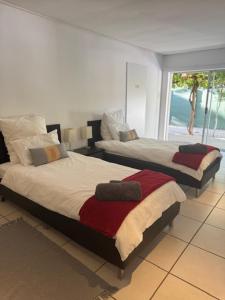 two beds in a bedroom with a view of the ocean at Flyers' Lodge in Porterville