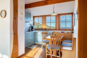 una cocina con armarios azules y una mesa y sillas de madera. en Ringlihof, en Horben