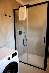 a washing machine in a bathroom with a shower at Cervo Felice Apartment in Belluno +33 photos