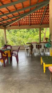 a group of tables and chairs on a patio at CANTINHO DA ROSA ac - RIO PRIVATIVO in Manhã