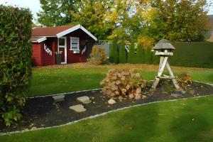- un jardin avec une fontaine en face d'une maison dans l'établissement Ferienwohnung Neumann, à Wesselburen