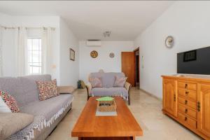 a living room with a couch and a tv at Flat3-5 Chaparil Beach in Nerja
