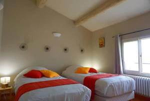 Dos camas en una habitación con ventana. en La Buisse - Les 2 Gites, en Simiane-la-Rotonde