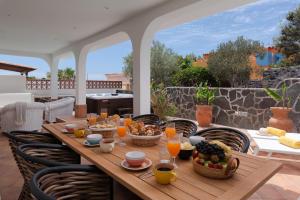 un tavolo in legno con cibo e bevande su un patio di Villa Estrella Del Mar Obsidian a Callao Salvaje