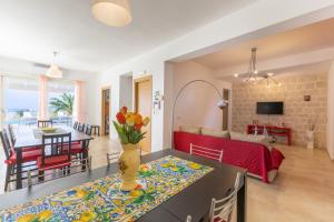 sala de estar y comedor con sofá rojo en Villa Marigù con spa e piscina, en Scicli