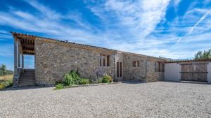 a stone house with a large driveway at Maison Time-out in Villevieille