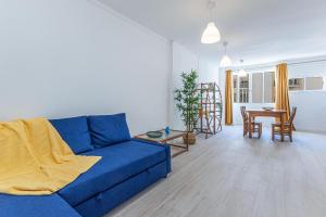 a living room with a blue couch and a table at Vieira Azul in Armação de Pêra