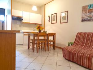 a kitchen and living room with a table and a couch at Apartment 4 beds with common swimming pool in Marina di Bibbona just 350 mt from the sea in Marina di Bibbona +5 photos