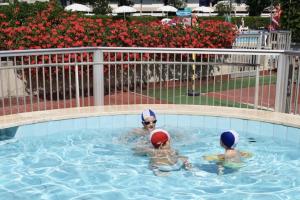 two people are swimming in a swimming pool at Apartment 4 beds with common swimming pool in Marina di Bibbona just 350 mt from the sea in Marina di Bibbona