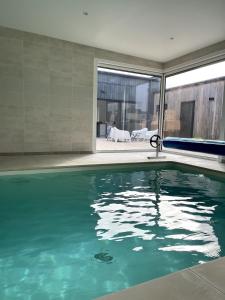 a swimming pool in the middle of a house at Villa Wax - Piscine et plage in Santec