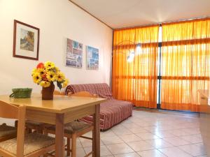 a living room with a table and a couch at ISA-Apartment 4 beds with common swimming pool in Marina di Bibbona just 350 mt from the sea in Marina di Bibbona