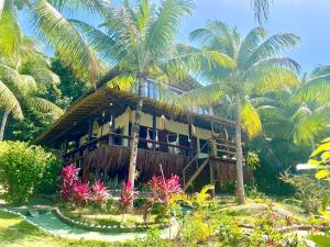 a resort with palm trees in front of a building at Casa Beija Flor ILHA DE BOIPEBA in Ilha de Boipeba