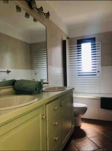 a bathroom with a sink and a toilet and a mirror at Villa Ballena in Lajares