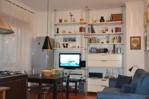 a living room with a tv and a table with a chair at L'Appartamento di Villa Bonelli in Rome