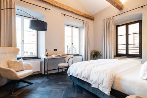 维皮泰诺Schwarzer Adler - Concept Living的一间卧室，有一张床、一张书桌和两扇窗户