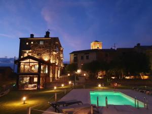 a swimming pool in front of a building at night at Boutique Hotel Tierra Buxo - Adults Only in Arcusa